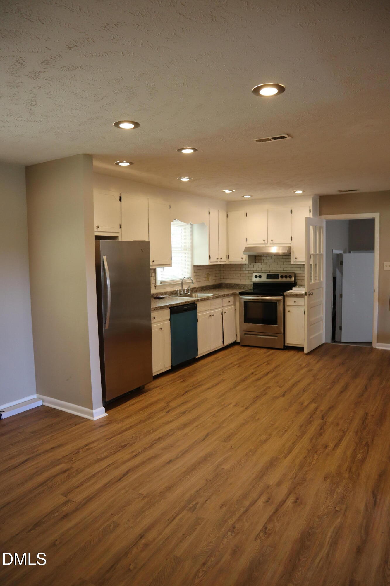 6591 Goldsboro Road Wade, NC 28395 - Photo 10 of 33 a large kitchen with stainless steel appliances granite countertop a stove a refrigerator a sink and a oven