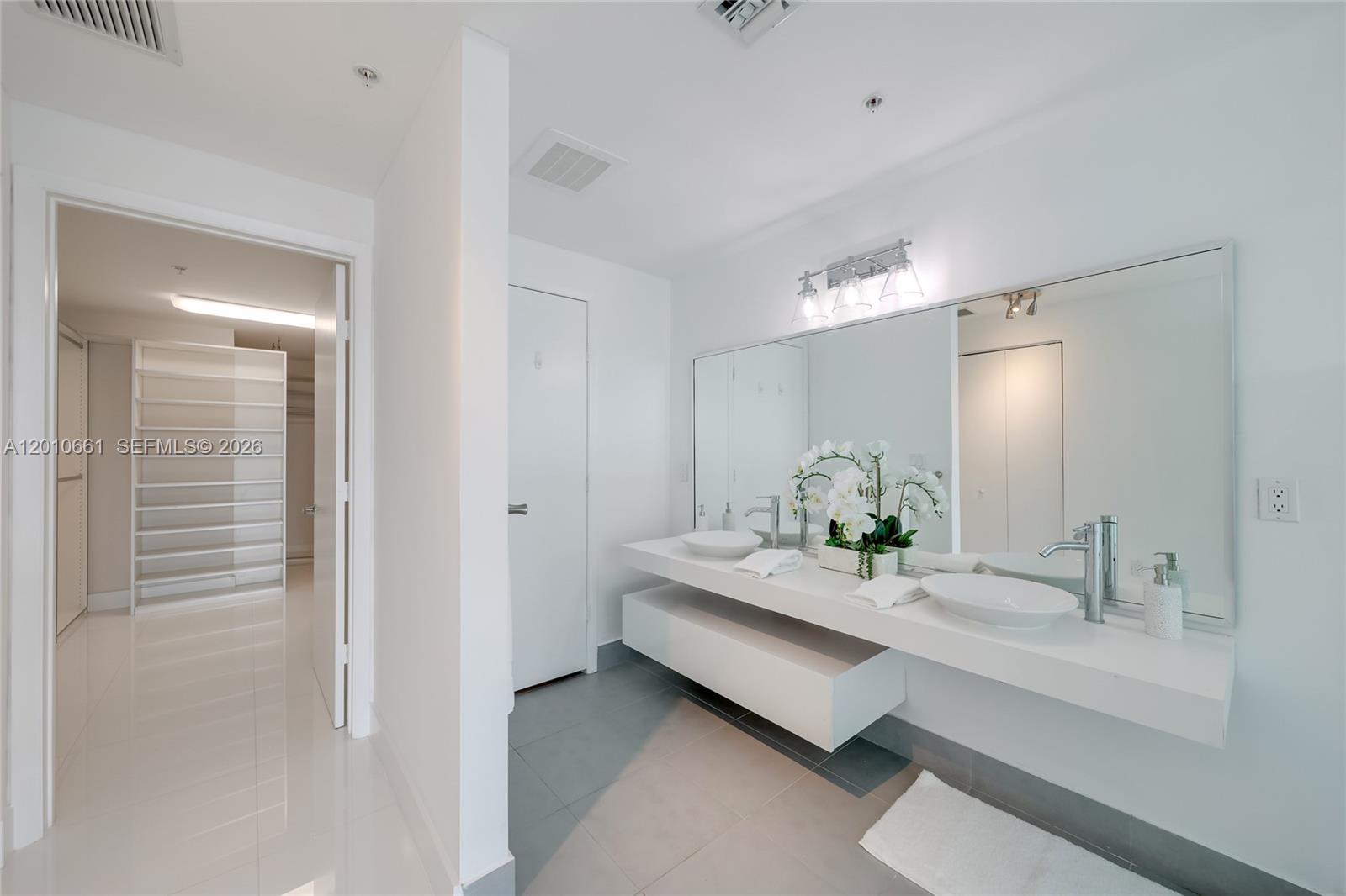 92 Southwest 3rd Street, Unit 5202 Miami, FL 33130 - Photo 13 of 27 a bathroom with a double vanity sink and a mirror