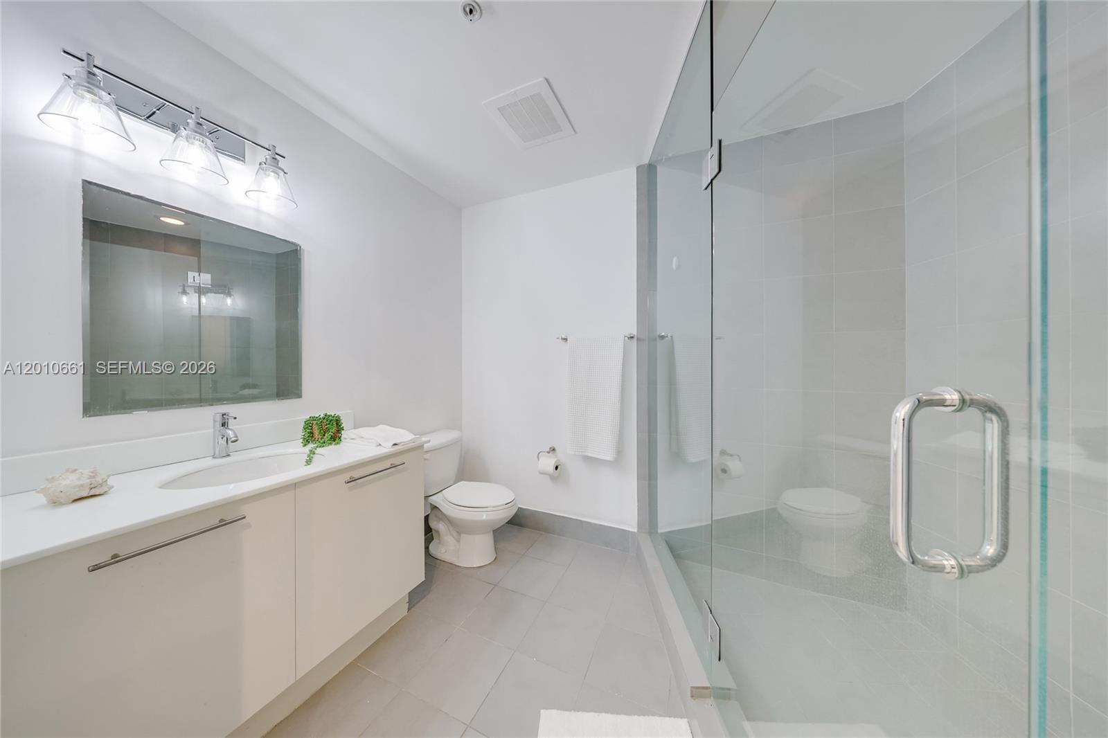 92 Southwest 3rd Street, Unit 5202 Miami, FL 33130 - Photo 16 of 27 a spacious bathroom with a double vanity sink toilet and shower