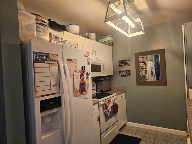 a view of kitchen with stainless steel appliances cabinets and a window