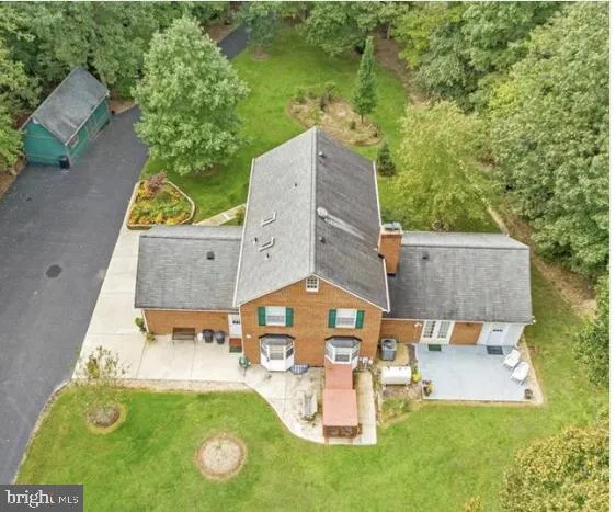 an aerial view of a house with swimming pool and garden