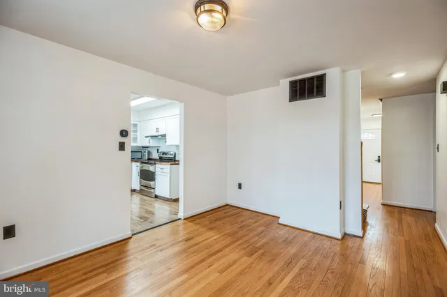 a view of empty room with wooden floor and window