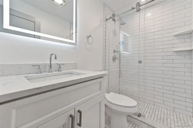 a bathroom with a sink a toilet and shower