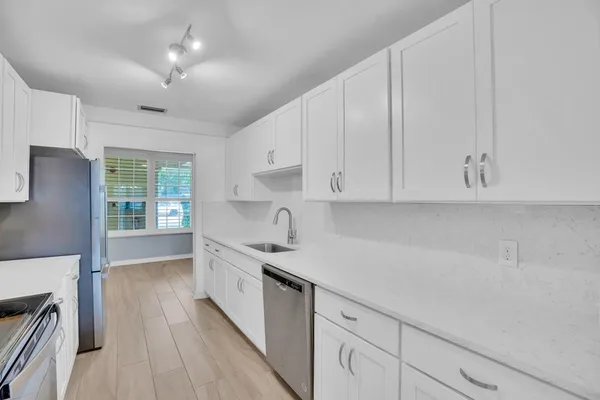 a kitchen with granite countertop white cabinets and white appliances