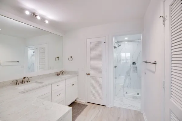 a spacious bathroom with a granite countertop sink a mirror a vanity and a bathtub