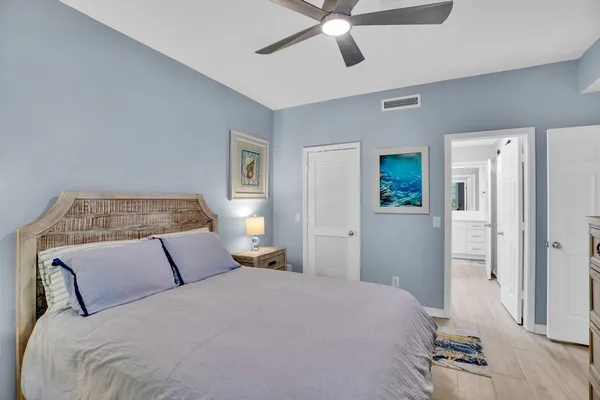 a bedroom with a large bed and a chandelier