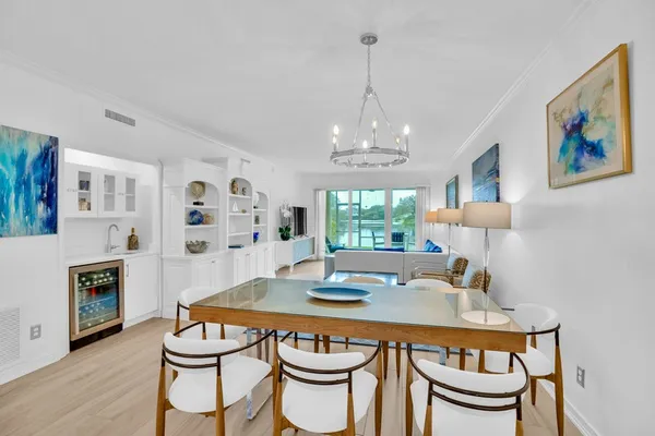 a dining room with furniture a chandelier and wooden floor