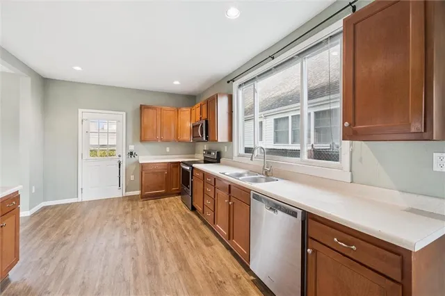 a kitchen with granite countertop a refrigerator a sink a stove and cabinets