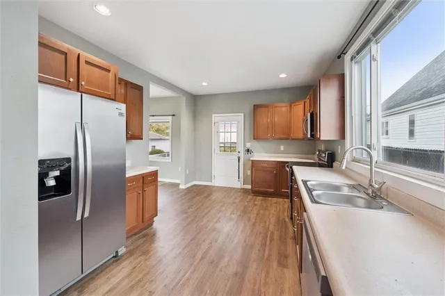 a view of kitchen with stainless steel appliances granite countertop a refrigerator and a sink