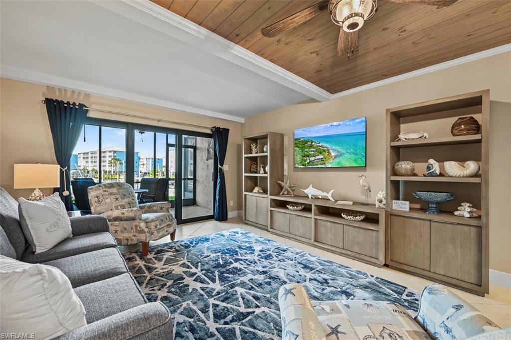 200 Lenell Road, Unit 215 Fort Myers Beach, FL 33931 - Photo 1 of 29 a living room with furniture a flat screen tv and floor to ceiling window