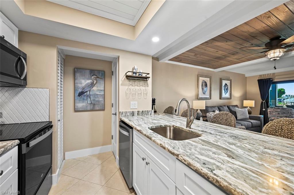 200 Lenell Road, Unit 215 Fort Myers Beach, FL 33931 - Photo 5 of 29 a kitchen with stainless steel appliances granite countertop a sink a stove and a wooden floors
