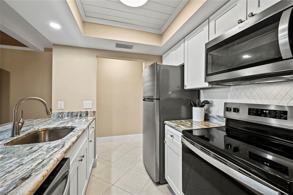 200 Lenell Road, Unit 215 Fort Myers Beach, FL 33931 - Photo 7 of 29 a kitchen with a stove and a microwave