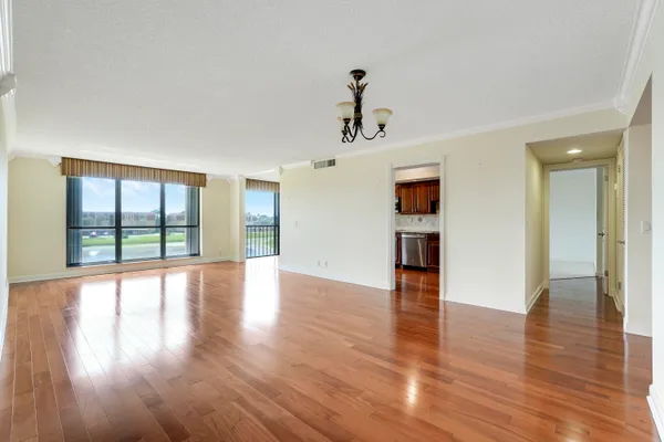 a view of empty room with wooden floor and windows