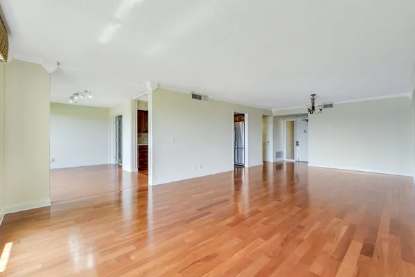 a view of empty room with wooden floor