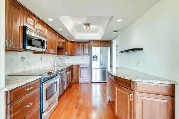 a large kitchen with stainless steel appliances granite countertop a stove a sink and a microwave