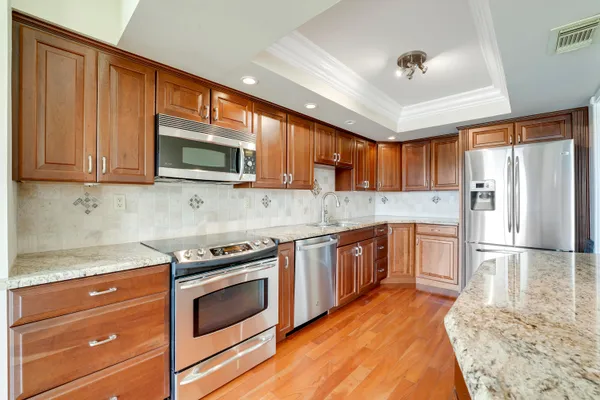 a kitchen with stainless steel appliances granite countertop wooden cabinets a stove top oven a sink and dishwasher