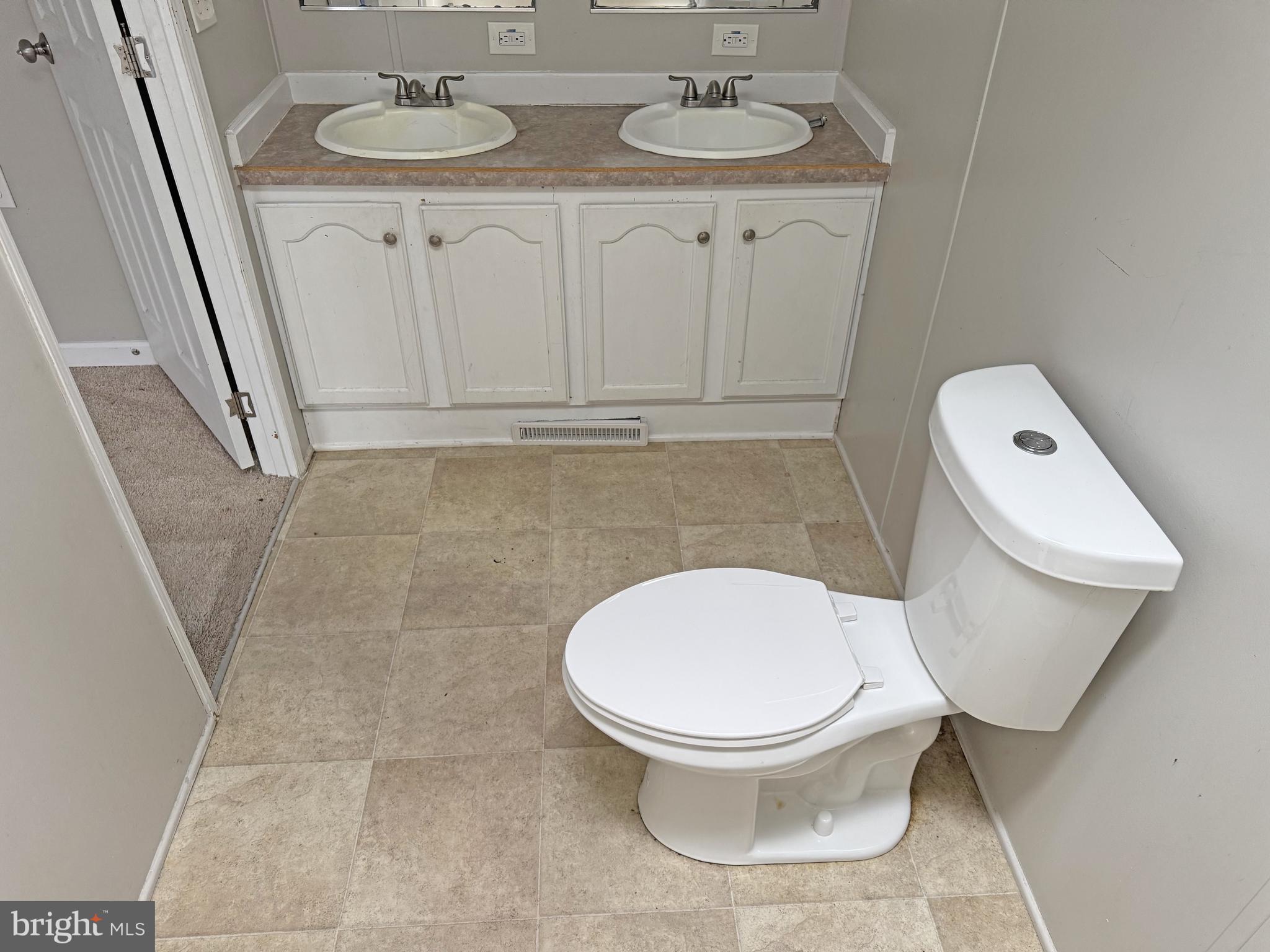 238 Silver Leaf Lane Dover, DE 19901 - Photo 12 of 20 a white toilet sitting next to a bathroom sink