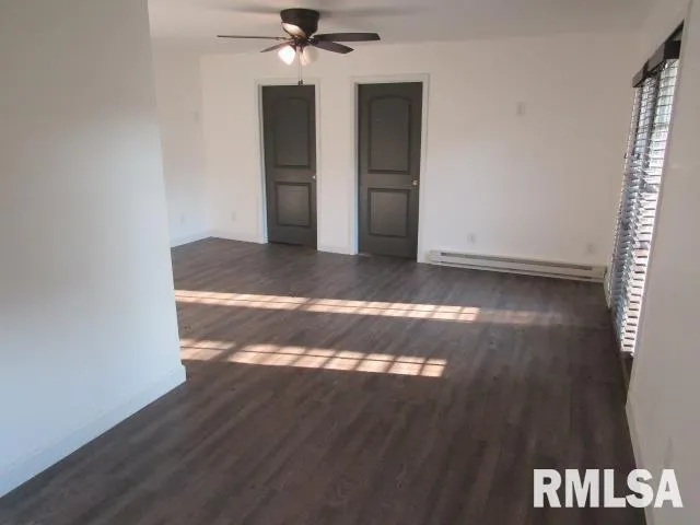 a view of a livingroom with wooden floor and a ceiling fan