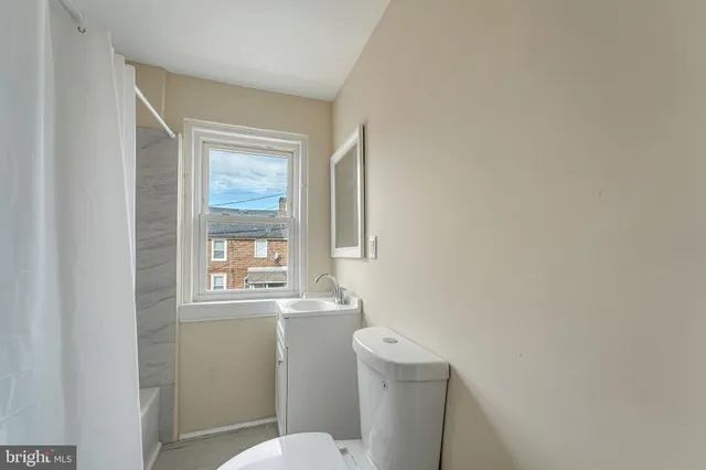 a bathroom with a toilet sink and mirror