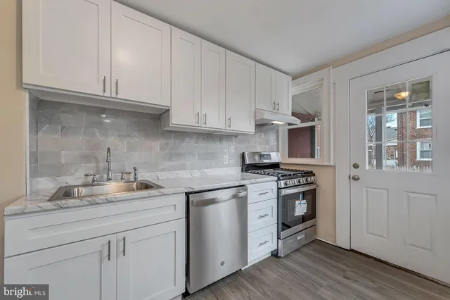 a kitchen with stainless steel appliances granite countertop a sink and stove top oven