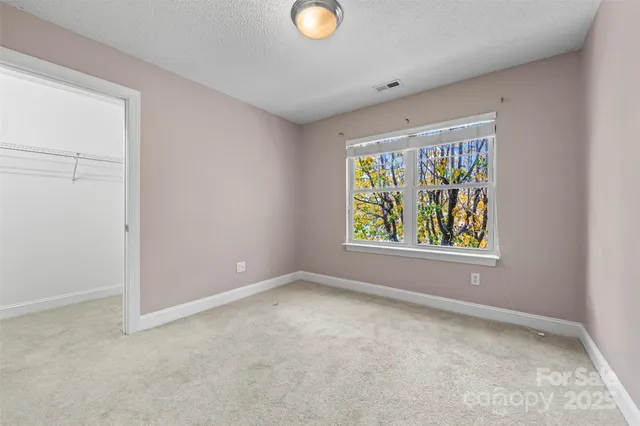 an empty room with windows and mirror