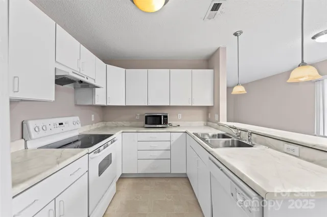 a kitchen that has a sink and a stove in it