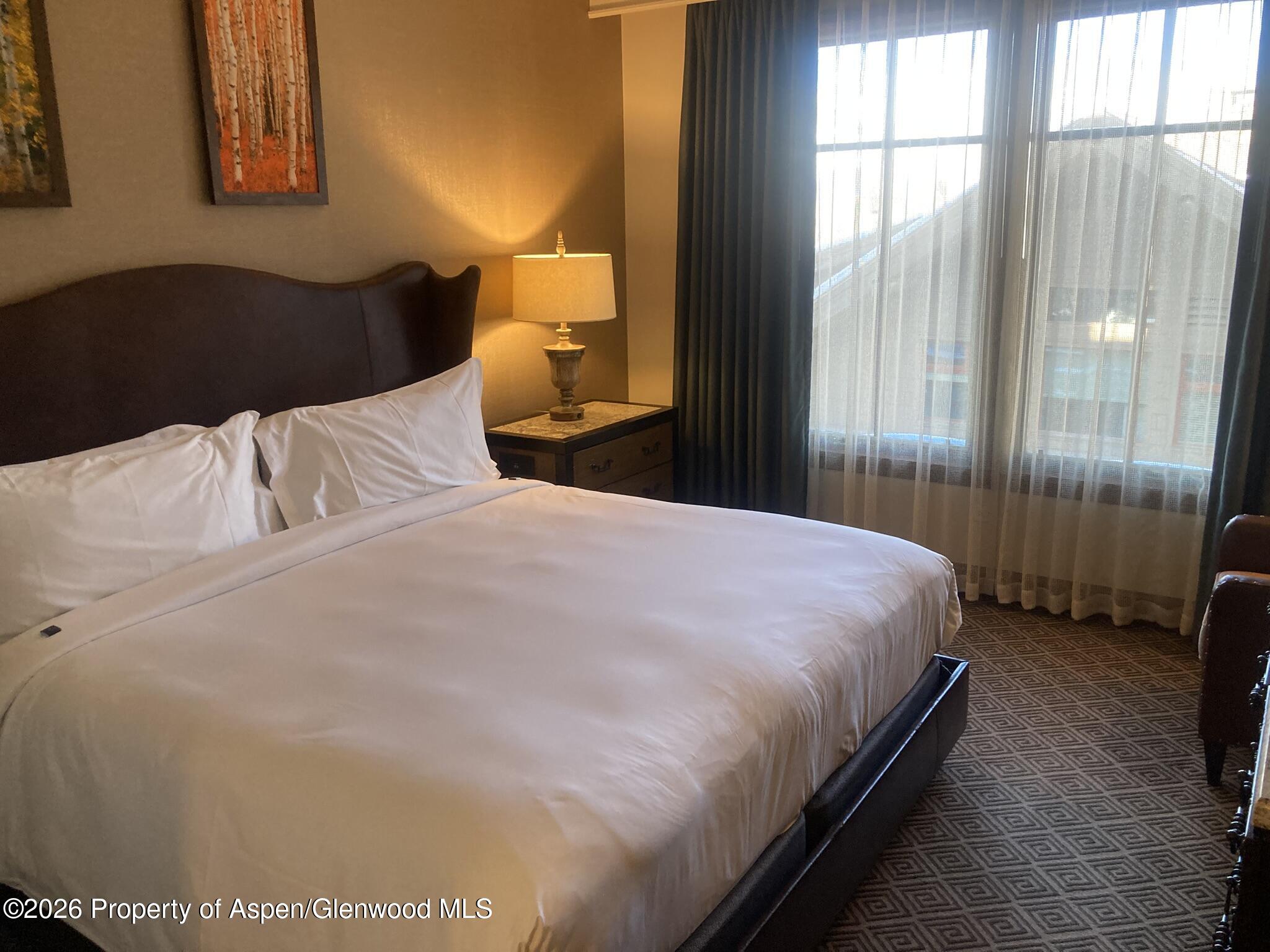 39 Boomerang Road, Unit 82104 Aspen, CO 81611 - Photo 7 of 22 a bedroom with a bed lamp and window