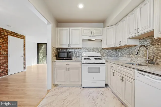a kitchen with white cabinets stainless steel appliances and sink
