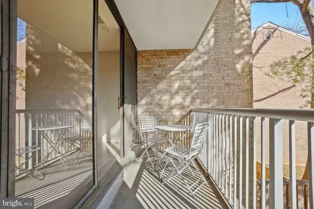 a view of a balcony with wooden floor and floor to ceiling window