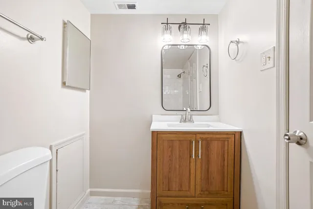 a bathroom with a granite countertop sink a mirror and vanity