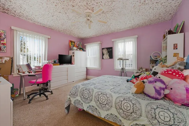 a bedroom with a bed large mirror and desk