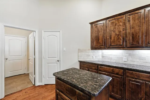 a kitchen with a sink a stove cabinets and wooden floor