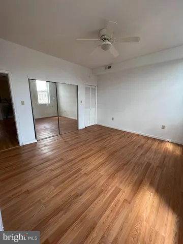 a view of empty room with wooden floor