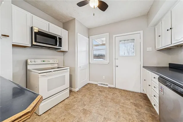a kitchen with stainless steel appliances granite countertop a stove and a microwave