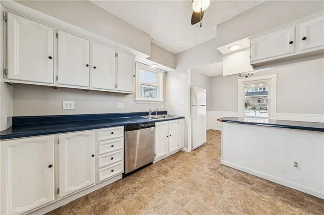 a kitchen with granite countertop white cabinets white stainless steel appliances and sink