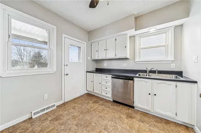 a kitchen with granite countertop a stove a sink and a refrigerator
