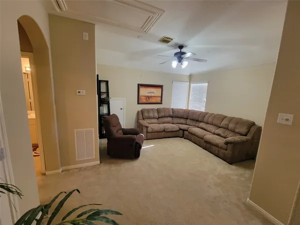 a living room with furniture and a ceiling fan