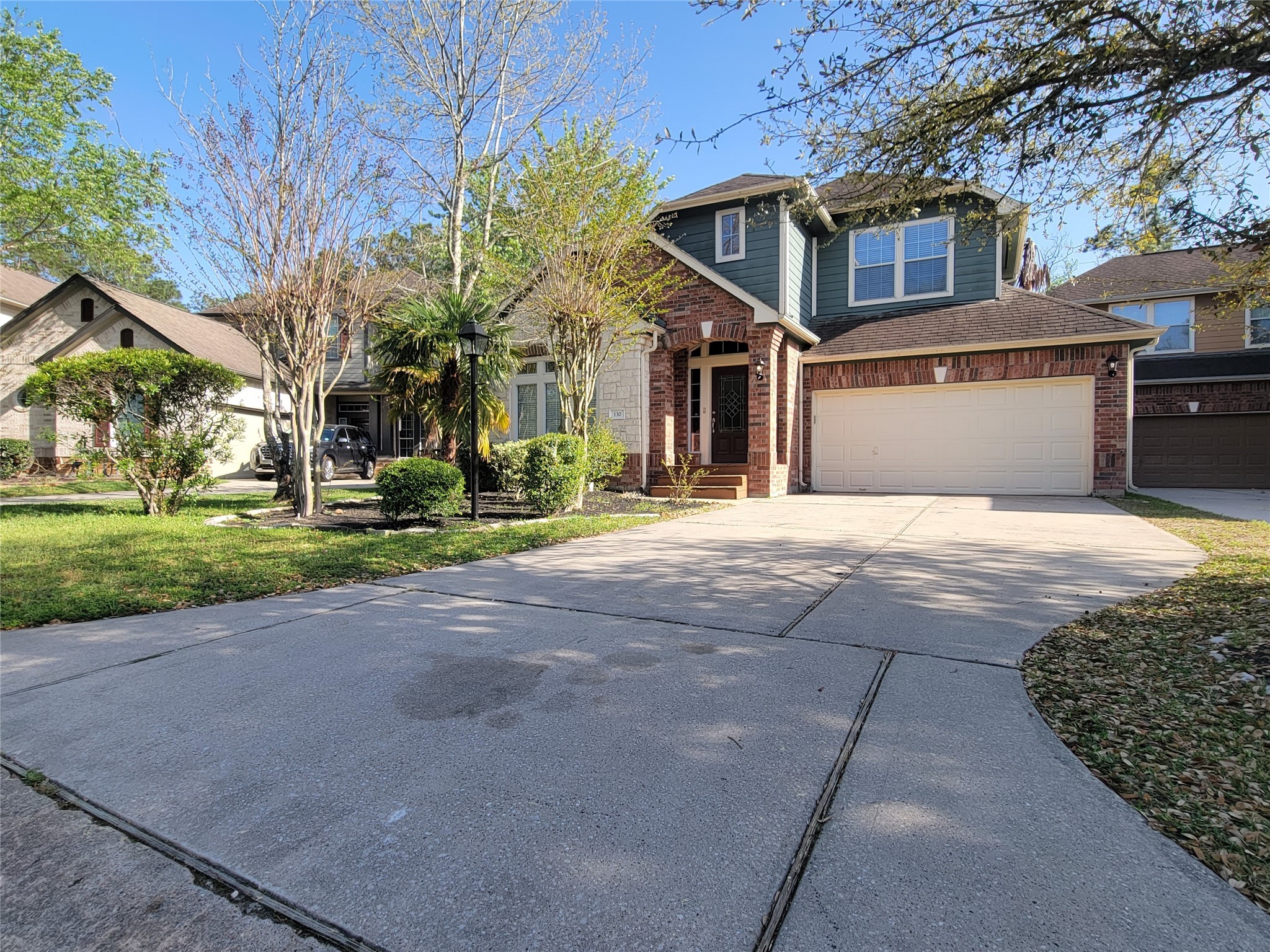 130 Zephyr Bend Place The Woodlands, TX 77381 - Photo 29 of 29 a front view of a house with a yard and potted plants