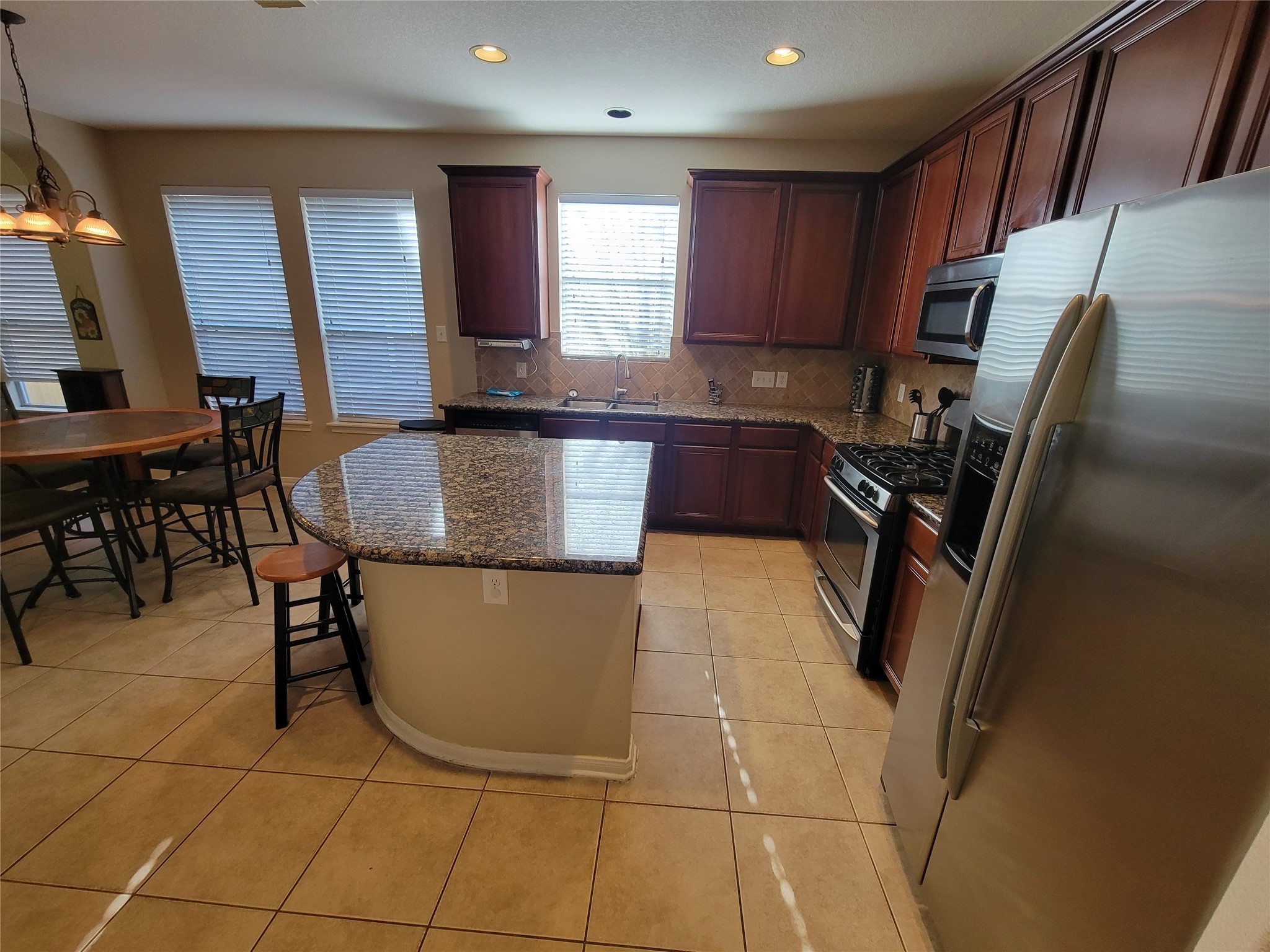 130 Zephyr Bend Place The Woodlands, TX 77381 - Photo 6 of 29 a kitchen with a sink a counter space cabinets and appliances