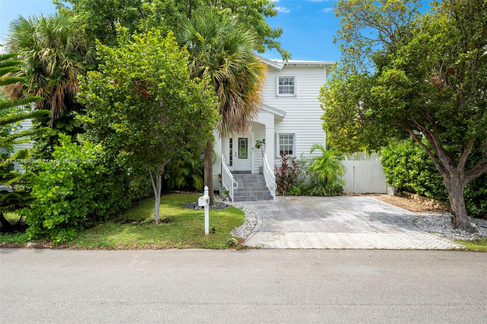 442 Fernwood Road Key Biscayne, FL 33149 - Photo 1 of 33 a front view of a house with a yard and trees