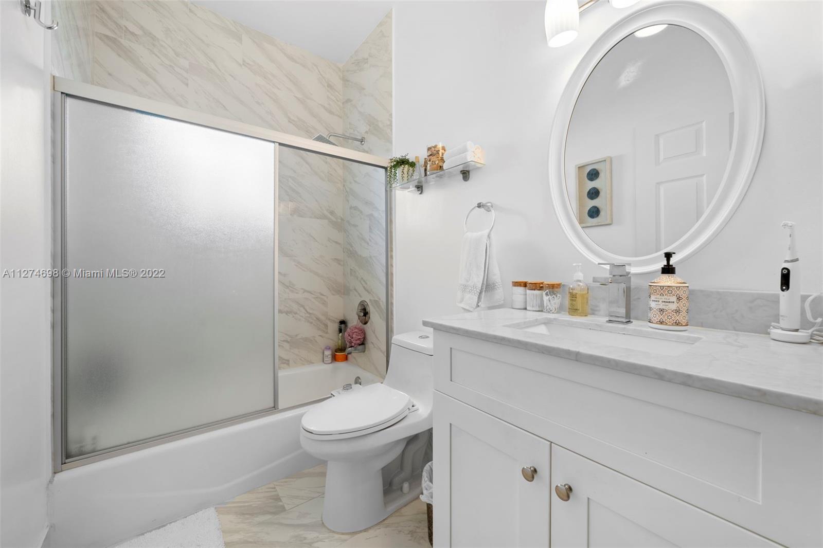 442 Fernwood Road Key Biscayne, FL 33149 - Photo 19 of 33 a bathroom with a sink a toilet and a mirror