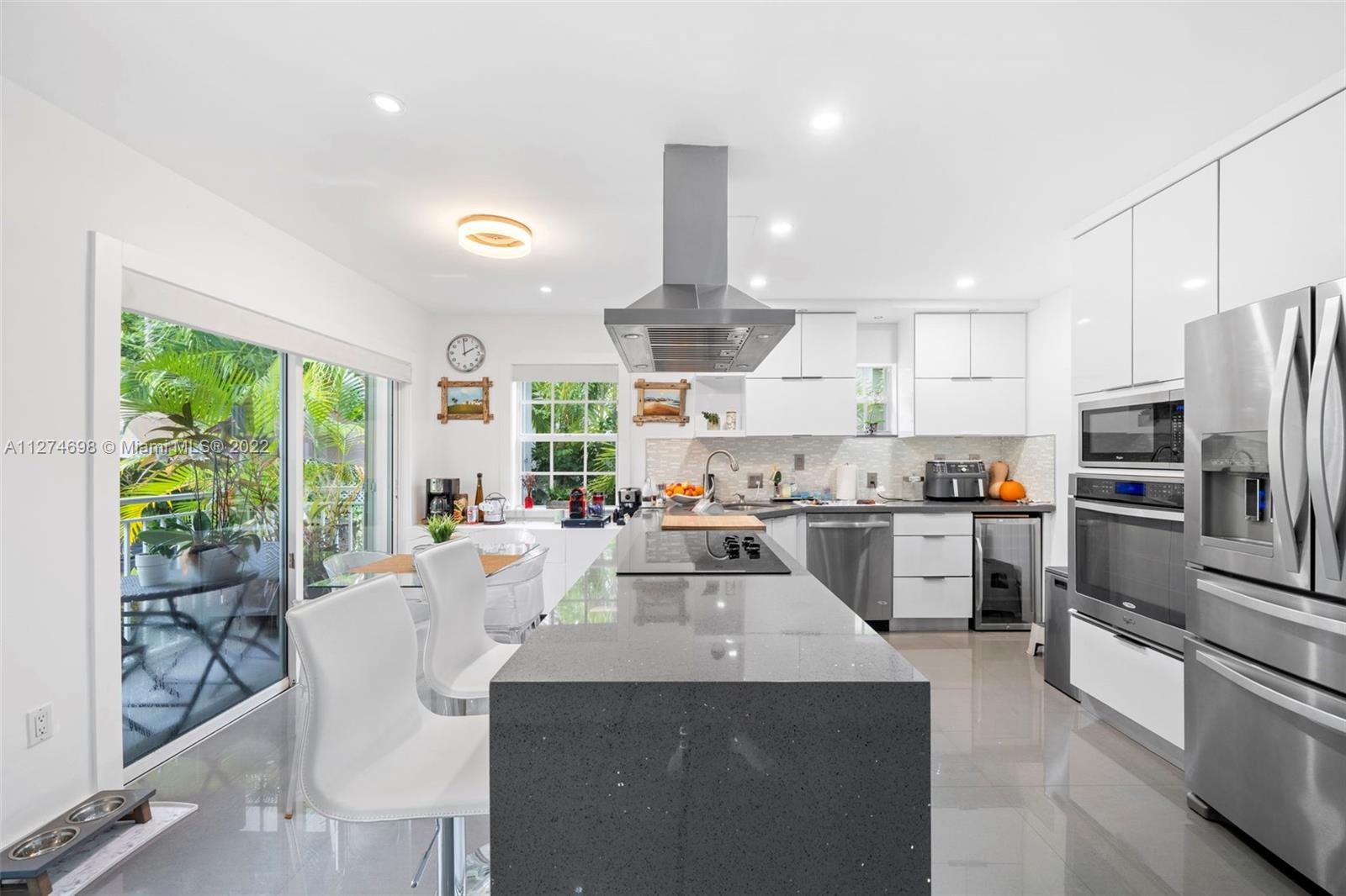 442 Fernwood Road Key Biscayne, FL 33149 - Photo 9 of 33 a kitchen with counter top space cabinets and stainless steel appliances