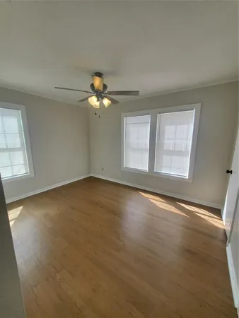 an empty room with a window and a ceiling fan