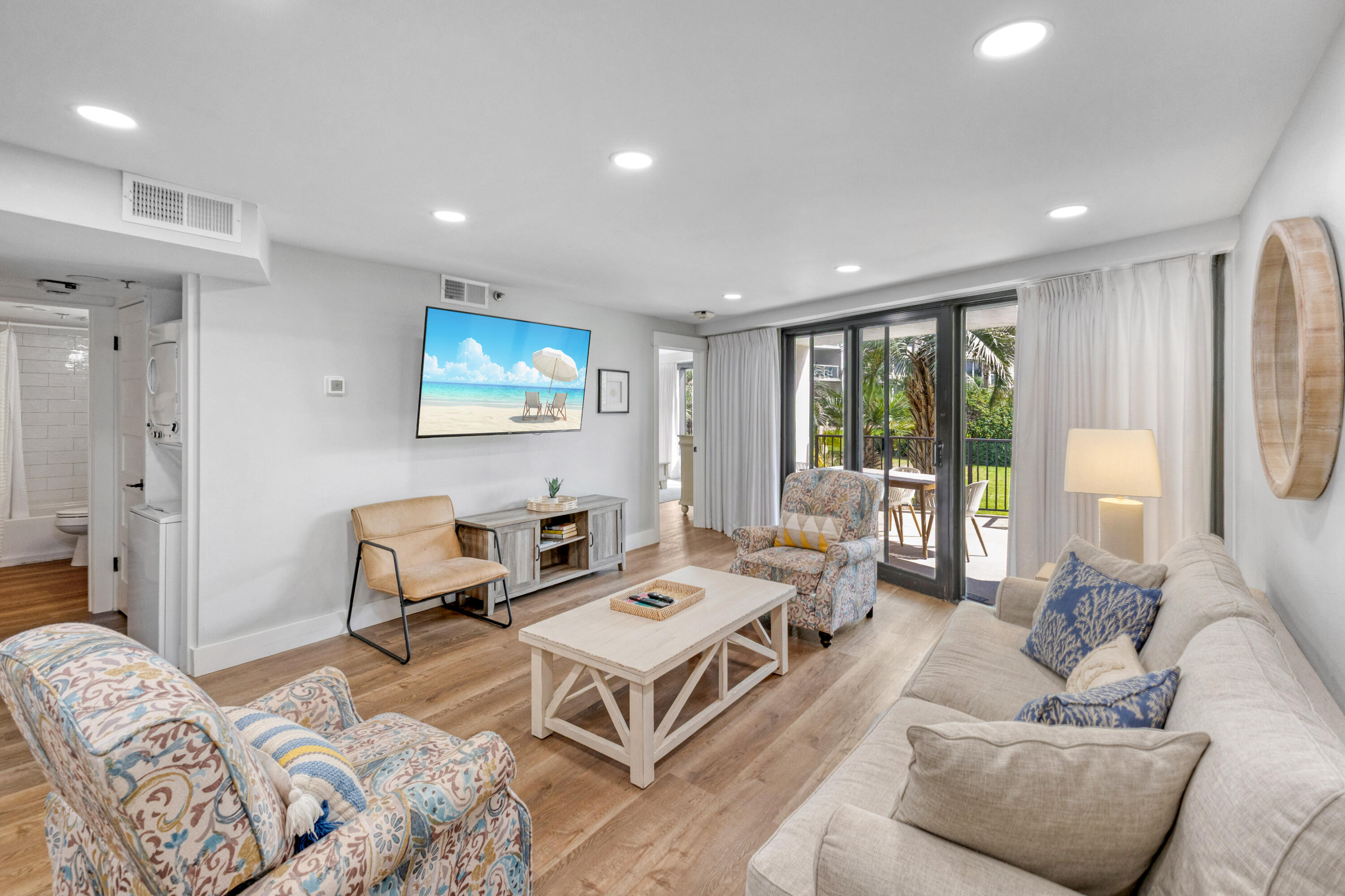 a living room with furniture flat screen tv and a large window