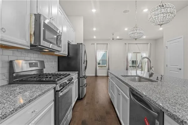 a kitchen with stainless steel appliances granite countertop a sink stove and refrigerator