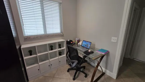 a view of a workspace with furniture and a window