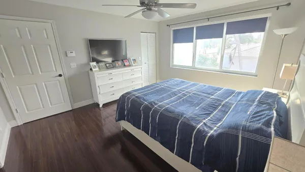 a bedroom with a bed and a flat tv screen on the dresser