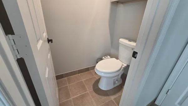 a white toilet sitting next to a sink and a mirror