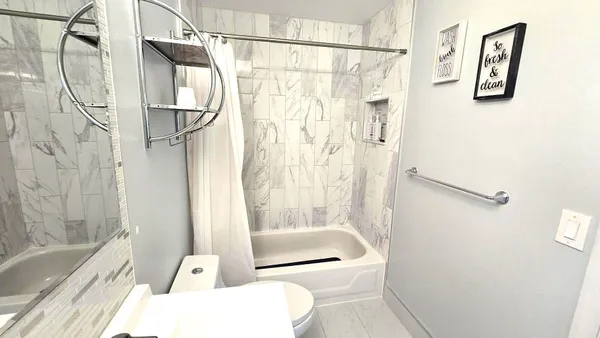 a bathroom with a shower and a toilet next to a window