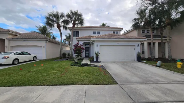 a view of a white house with a yard and plants